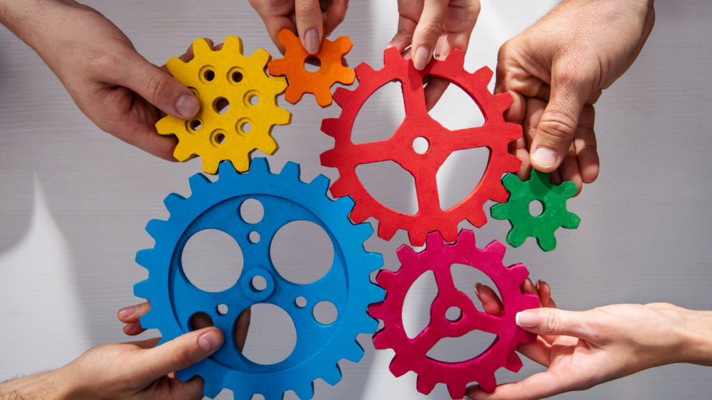 Hands holding interlocking gears, representing collaboration and teamwork